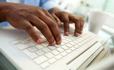 a man's hands typing on a keyboard